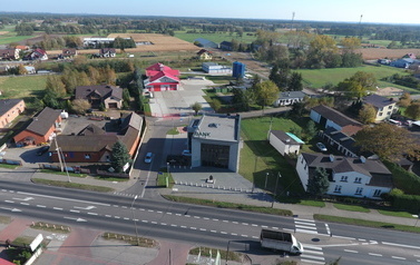 Zdjęcie Cekowa z drona, na pierwszym planie budynek banku sp&oacute;łdzielczego, w centrum strażnica osp, w tle zabudowania stacji uzdatniania wody